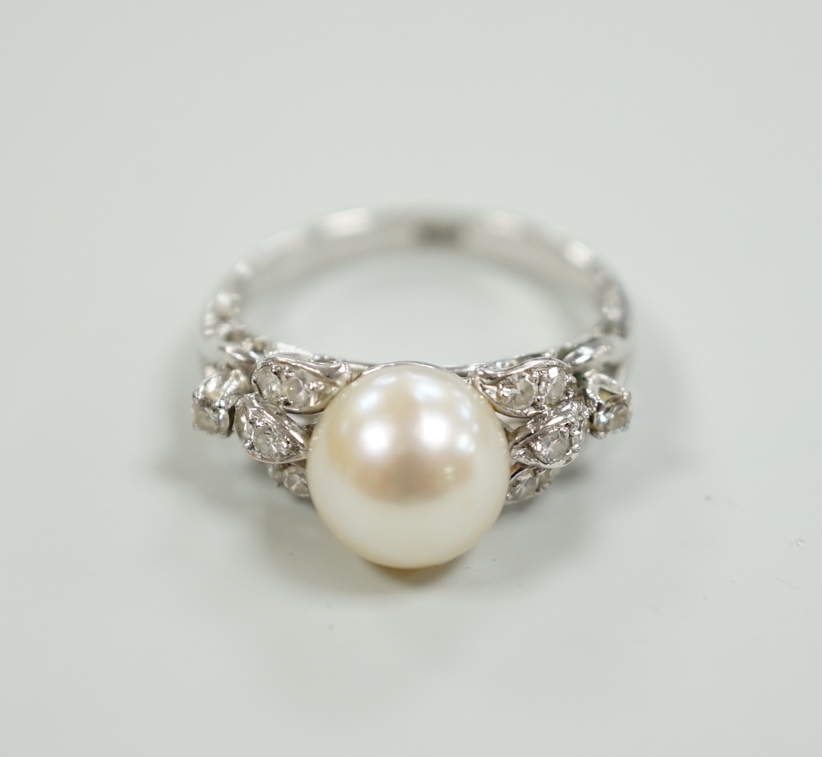 A 14k white metal and single stone cultured pearl set dress ring, with diamond cluster set shoulders, size J, gross weight 3.4 grams.